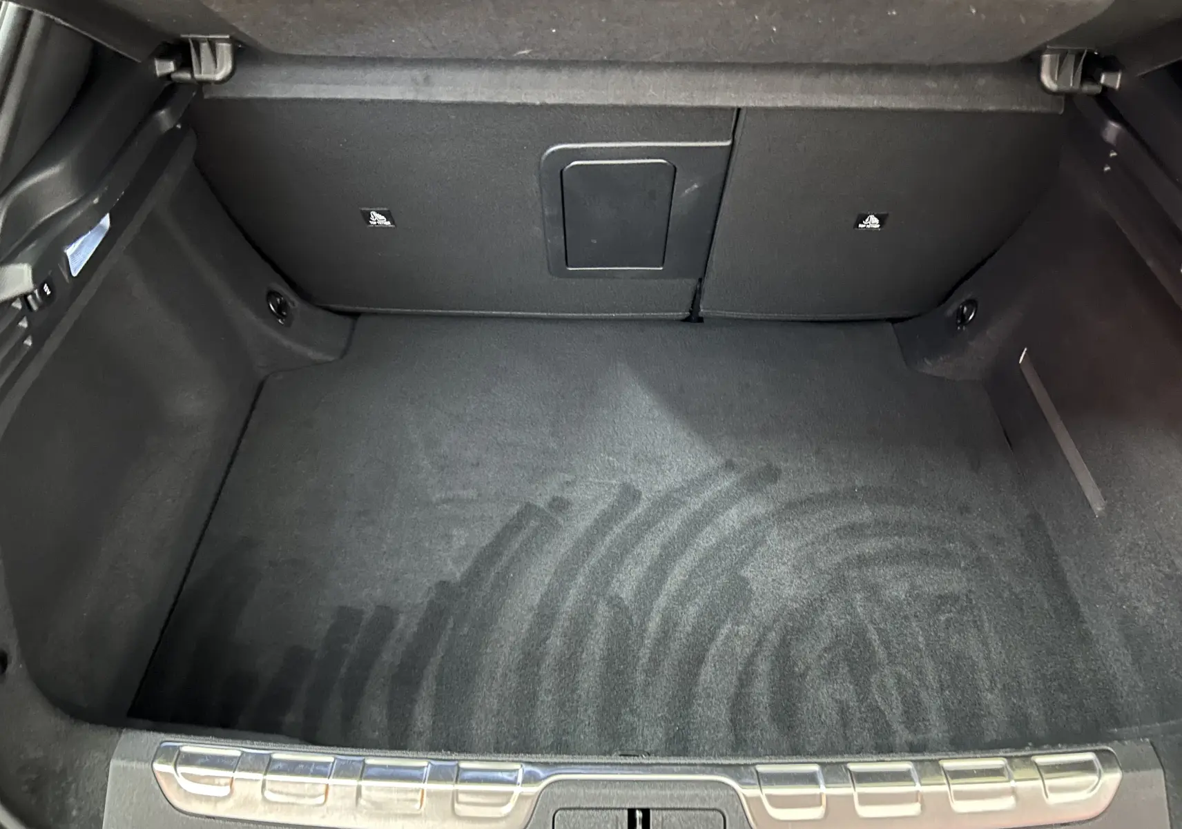 Coffre spacieux et propre du DS4 2024 en noir Perla Nera, vue intérieure depuis l'arrière avec seuil métallique de protection.
