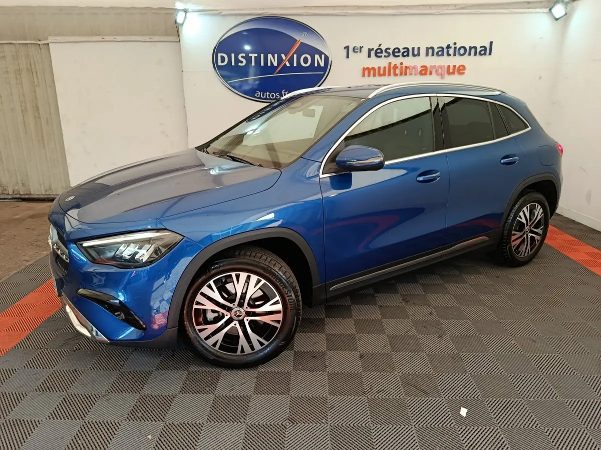 Mercedes GLA 250 e Business Line bleu en 3/4 avant droit, avec jantes alliage et rétroviseurs chromés dans un showroom.