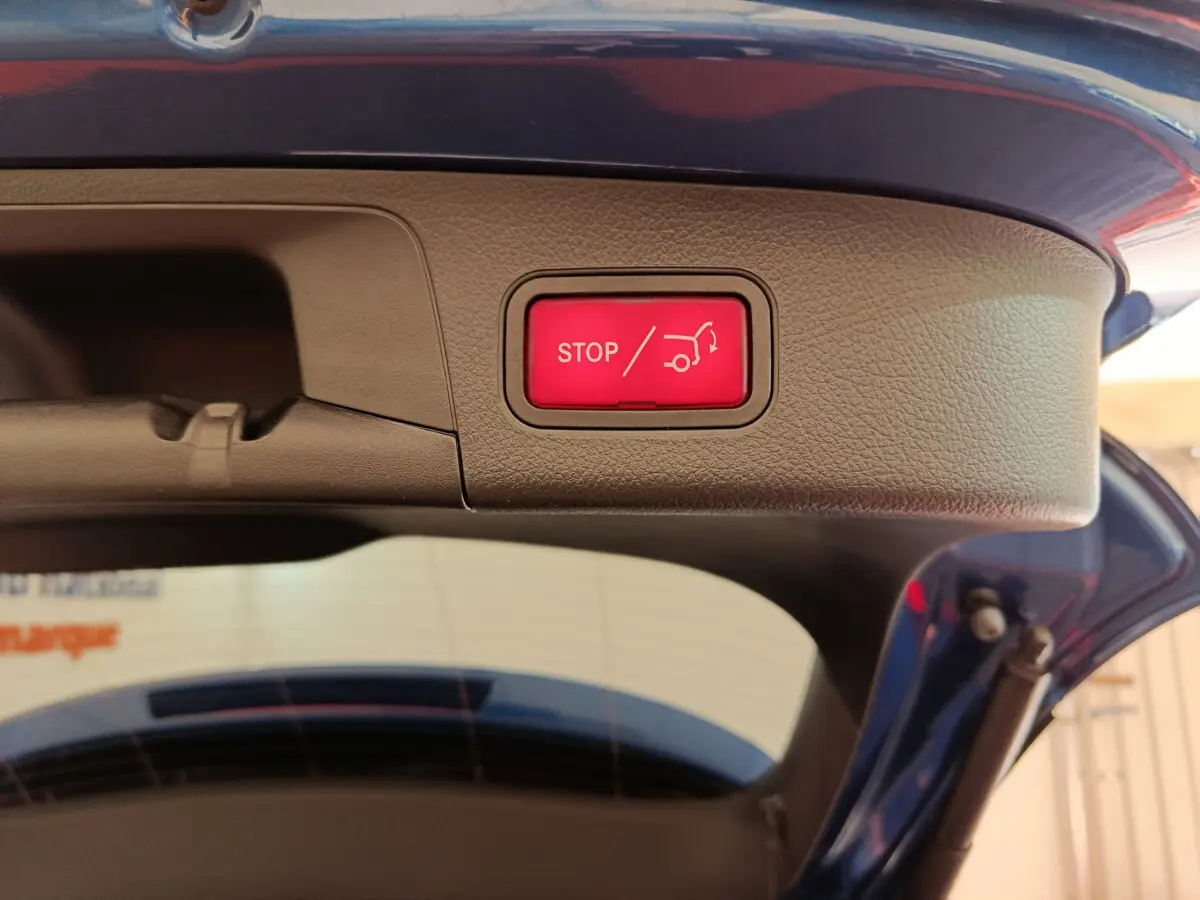 Bouton rouge stop pour fermeture électrique du coffre sur la partie intérieure du hayon d'un Mercedes GLA 250 e bleu 2024