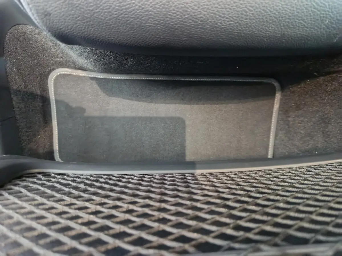 Tapis de sol noir avec surpiqûres blanches dans l'habitacle du Mercedes GLA 250 e Business Line 2024.