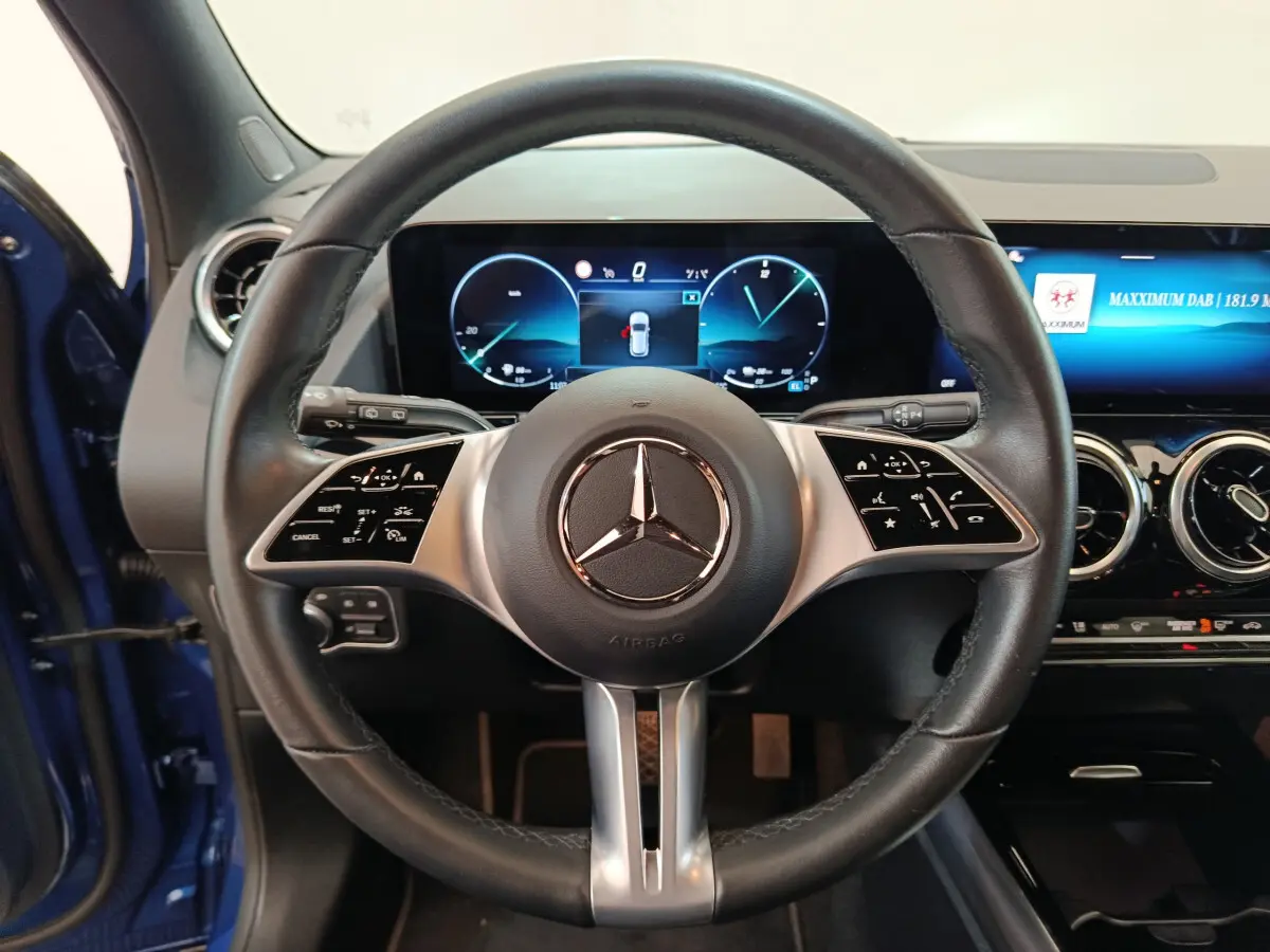 Vue frontale du volant cuir noir de la Mercedes GLA 250 e Business Line 2024 avec tableau de bord numérique et écran tactile.