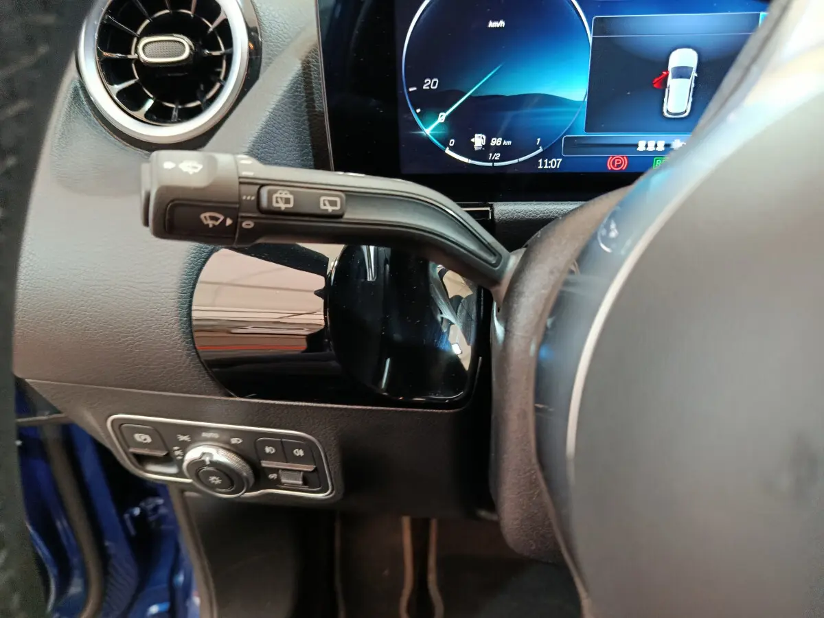 Gros plan sur le volant et le combiné d'instruments numérique du Mercedes GLA 250 e Business Line bleu, côté conducteur.