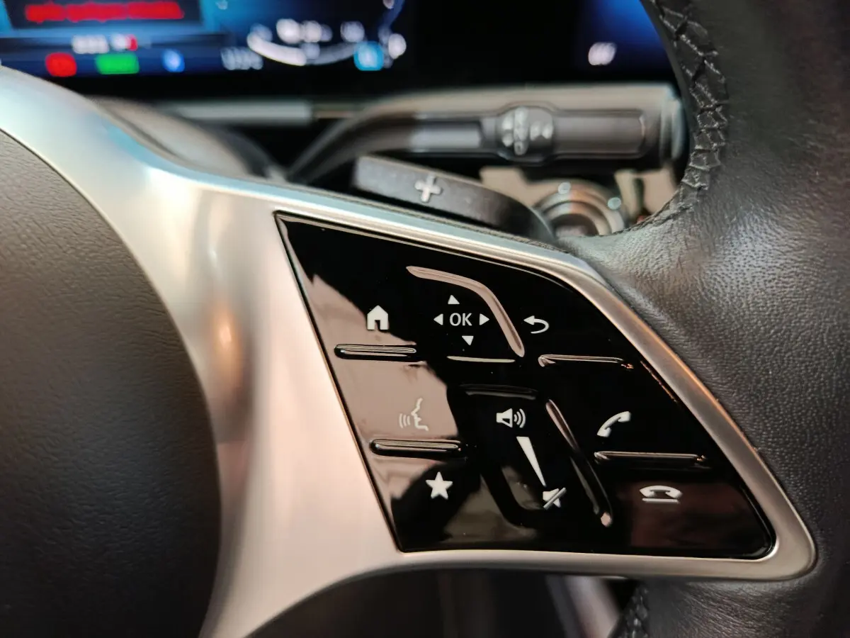 Gros plan sur les commandes tactiles du volant cuir du Mercedes GLA 250 e Business Line 2024 hybride rechargeable.