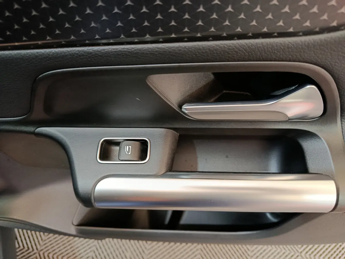 Poignée intérieure côté gauche avec bouton de verrouillage, finition noire et argentée du Mercedes GLA 250 e 2024.