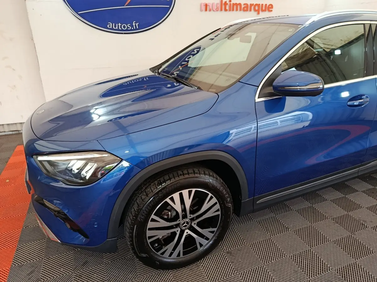 Vue 3/4 avant droit d'un Mercedes GLA 250 e Business Line bleu avec jante alliage et rétroviseur assorti.