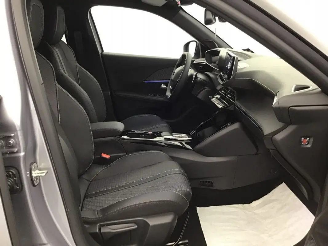 Vue intérieure côté conducteur du Peugeot 2008 Hybrid 145ch GT 2025, sièges noirs et tableau de bord moderne.