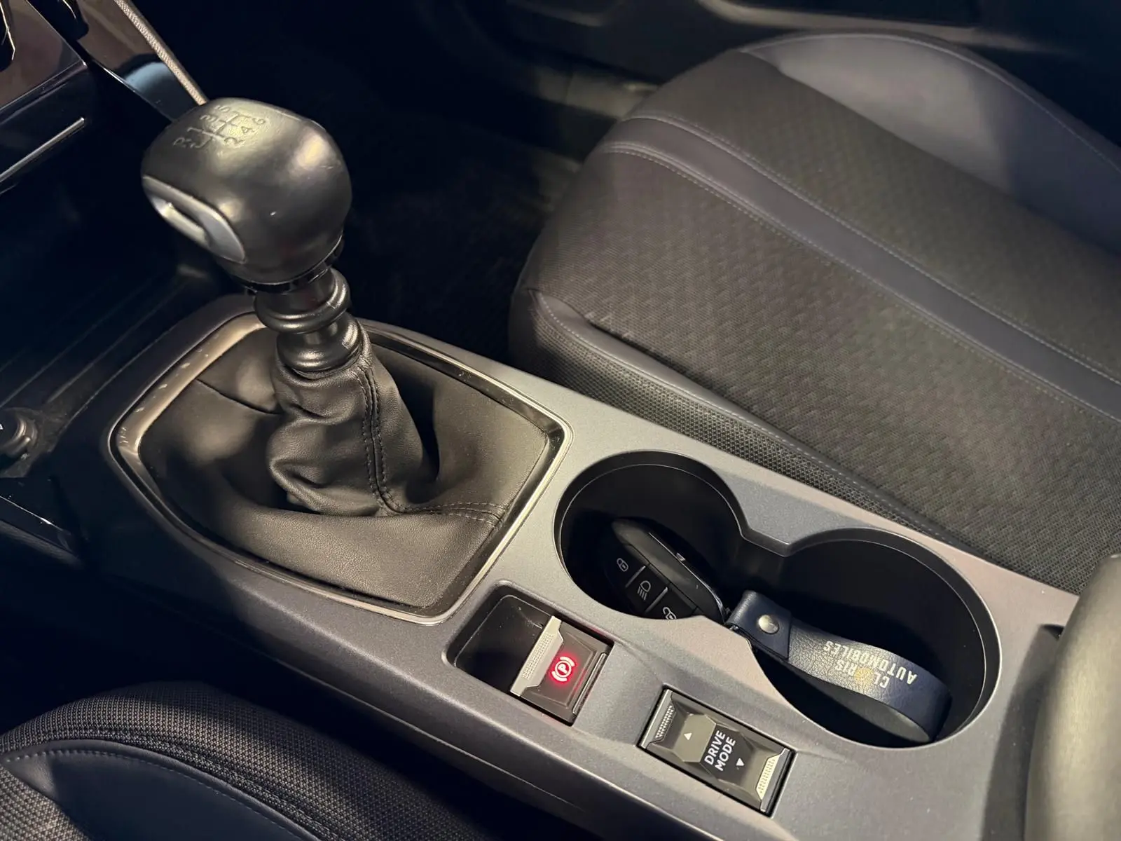 Gros plan sur la console centrale de la Peugeot 2008 2020 avec levier de vitesse manuel et porte-gobelets.
