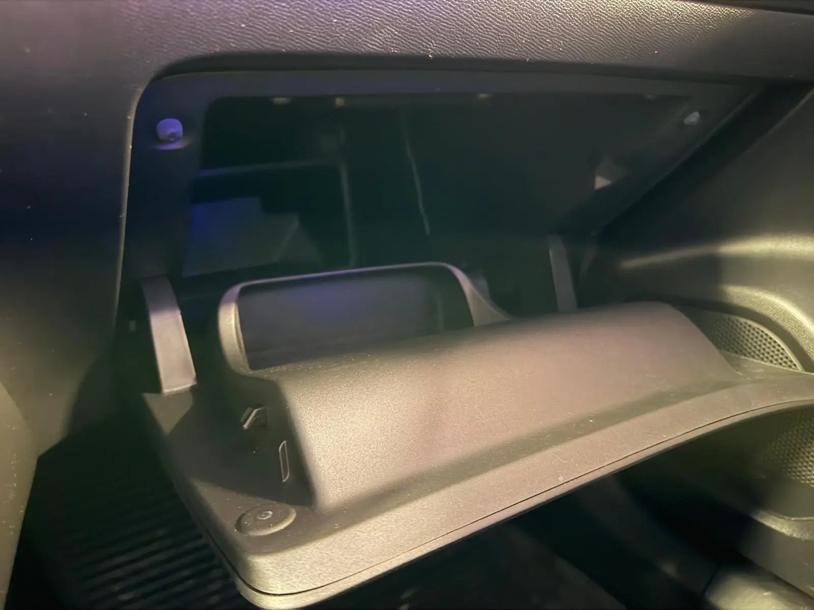 Gros plan sur la boîte à gants ouverte de la Peugeot 2008 1.5 BlueHDi 100 Allure, intérieur noir.