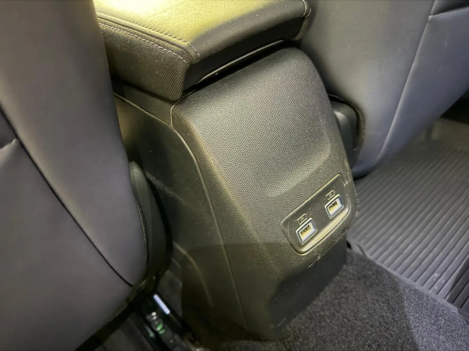 Prise USB double arrière sur console centrale noire entre sièges arrière d’une Peugeot 2008 1.5 BlueHDi 2020.