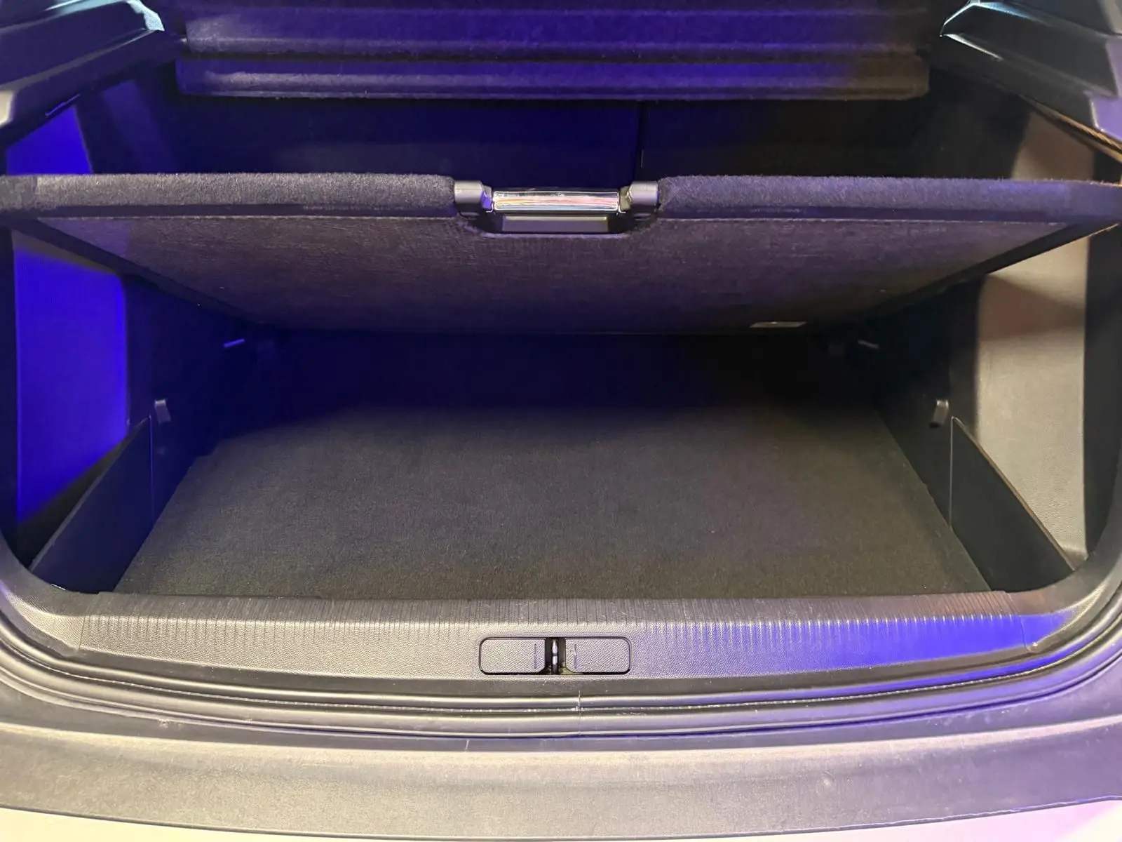 Coffre ouvert vu de face d'un Peugeot 2008 1.5 BlueHDi 100 Allure, intérieur noir avec plancher plat.