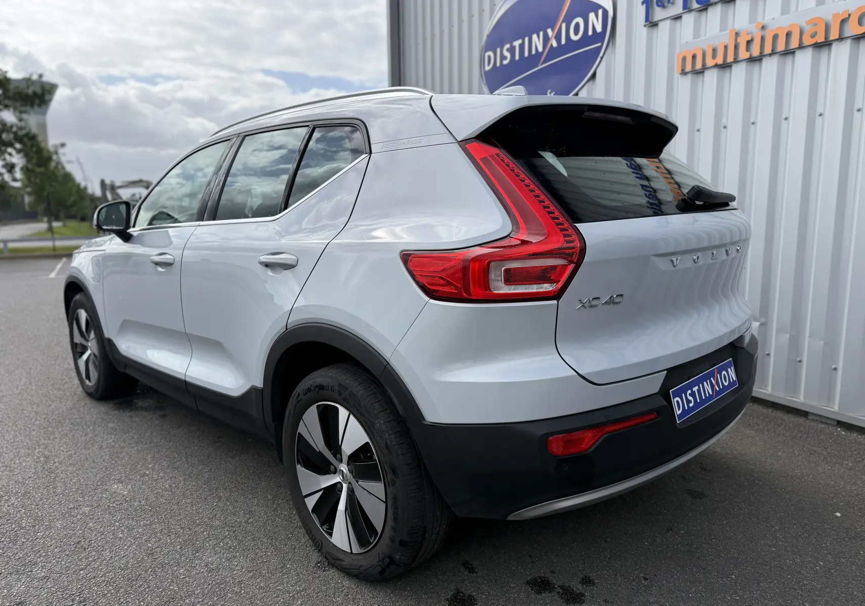 Vue 3/4 arrière droite d’un Volvo XC40 blanc Crystal Metal avec feux arrière en forme de L et jantes bicolores.