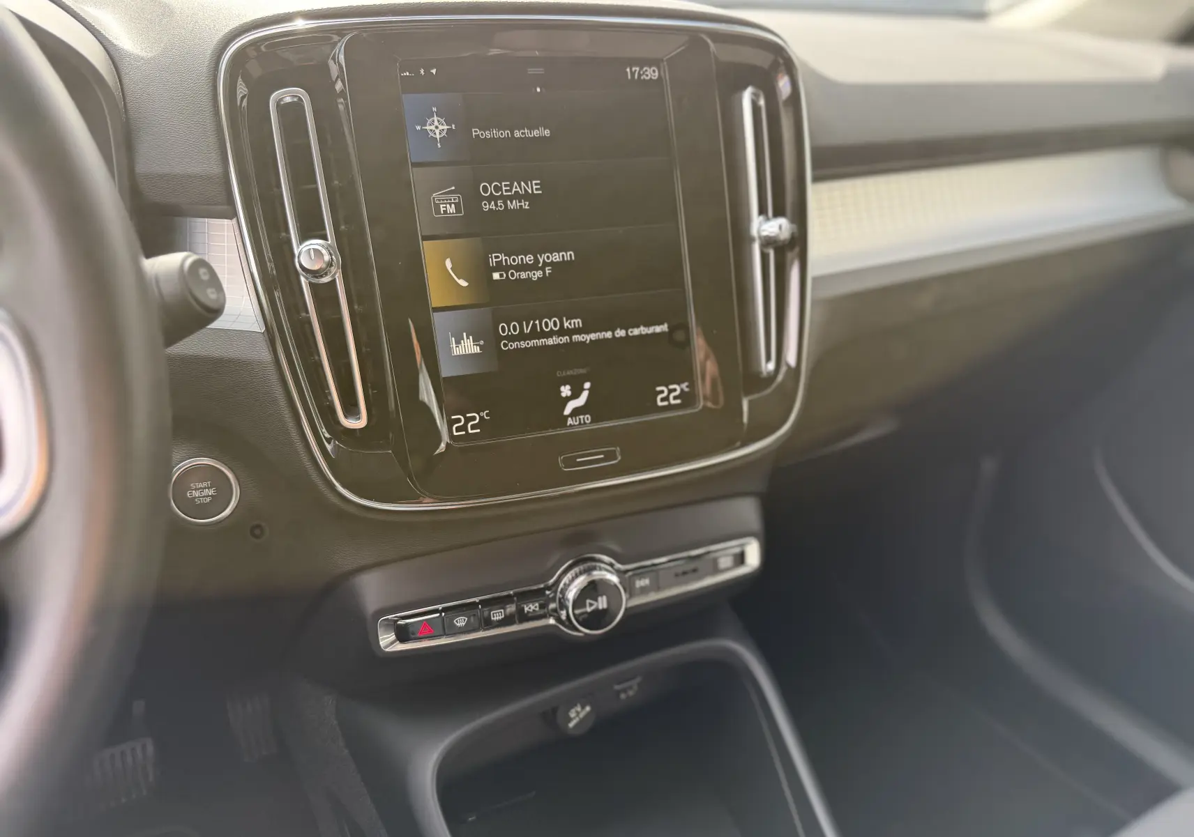 Vue intérieure du tableau de bord du Volvo XC40 hybride rechargeable, avec écran tactile central et commandes climatisation visibles.