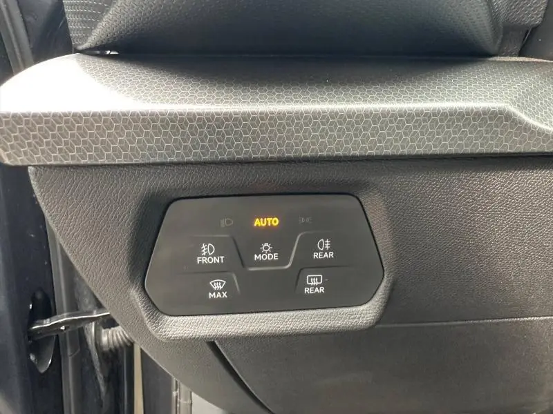 Gros plan sur les commandes d’éclairage et de désembuage côté gauche, intérieur noir du SEAT Leon 2025.