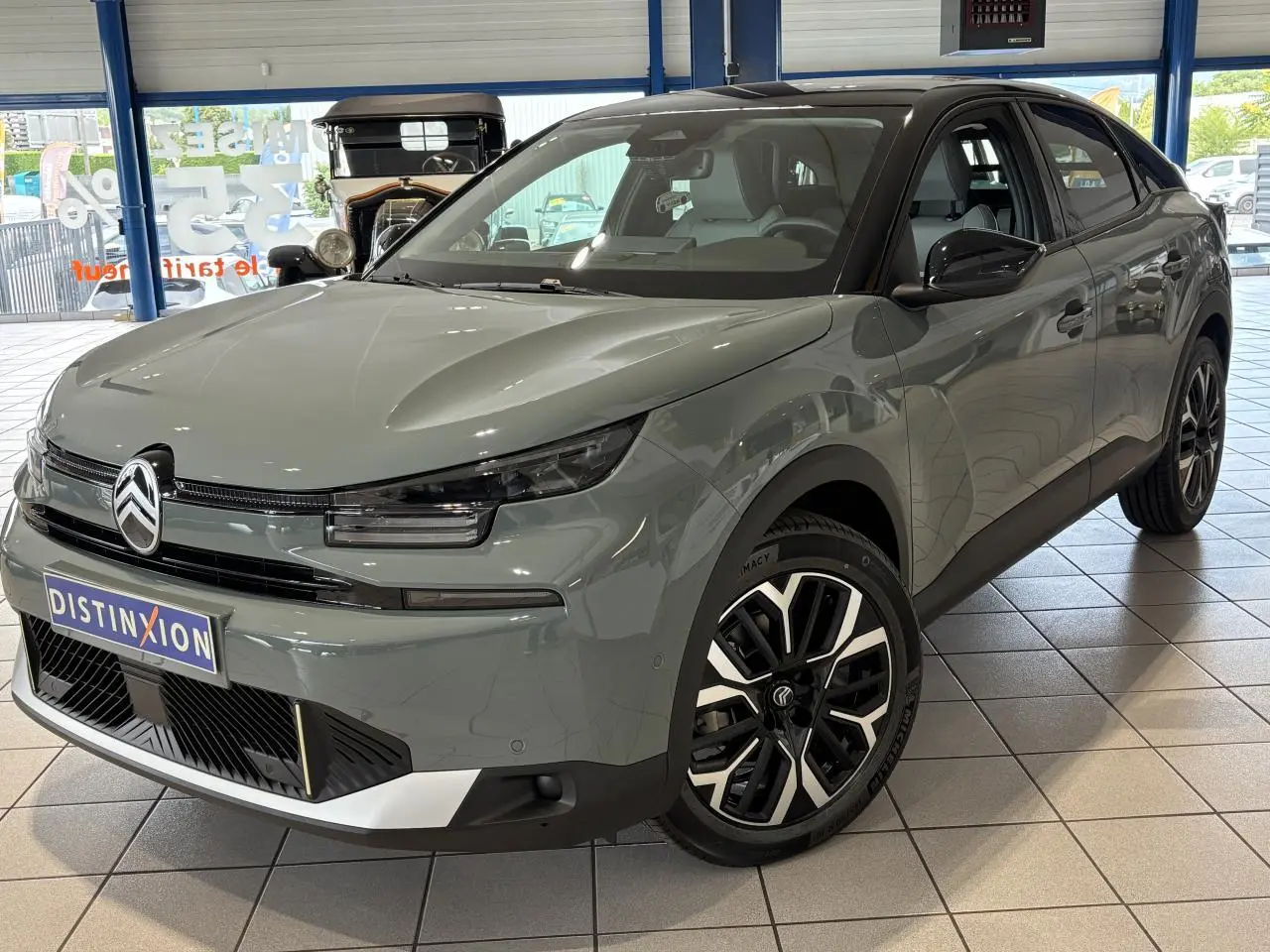 Citroën C4 vert Manhattan en 3/4 avant droit, toit noir bi-ton et jantes alliage 18 pouces visibles en showroom.