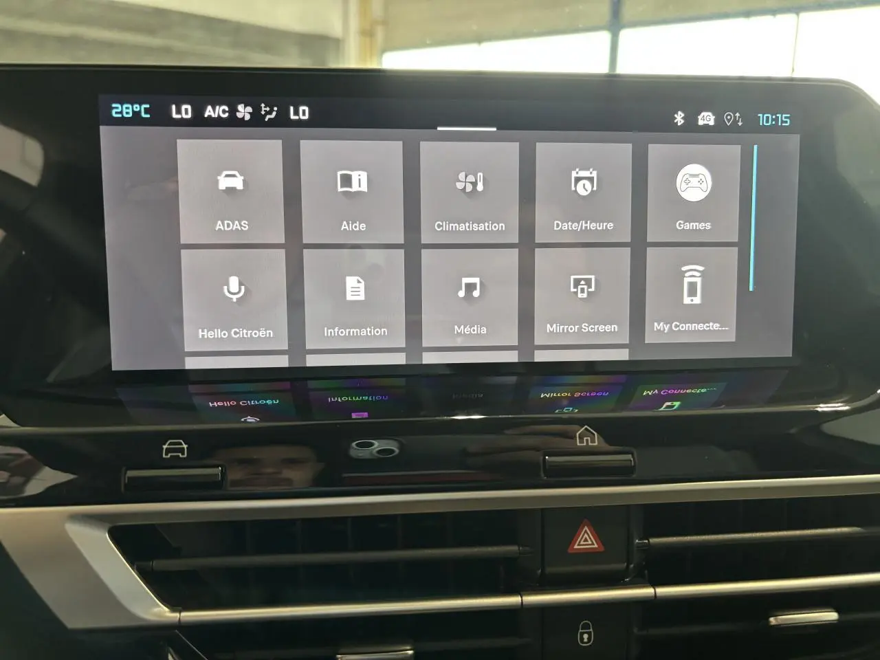 Écran tactile central de la Citroën C4 hybride 2026 affichant les options de menu, avec aérateurs en dessous.