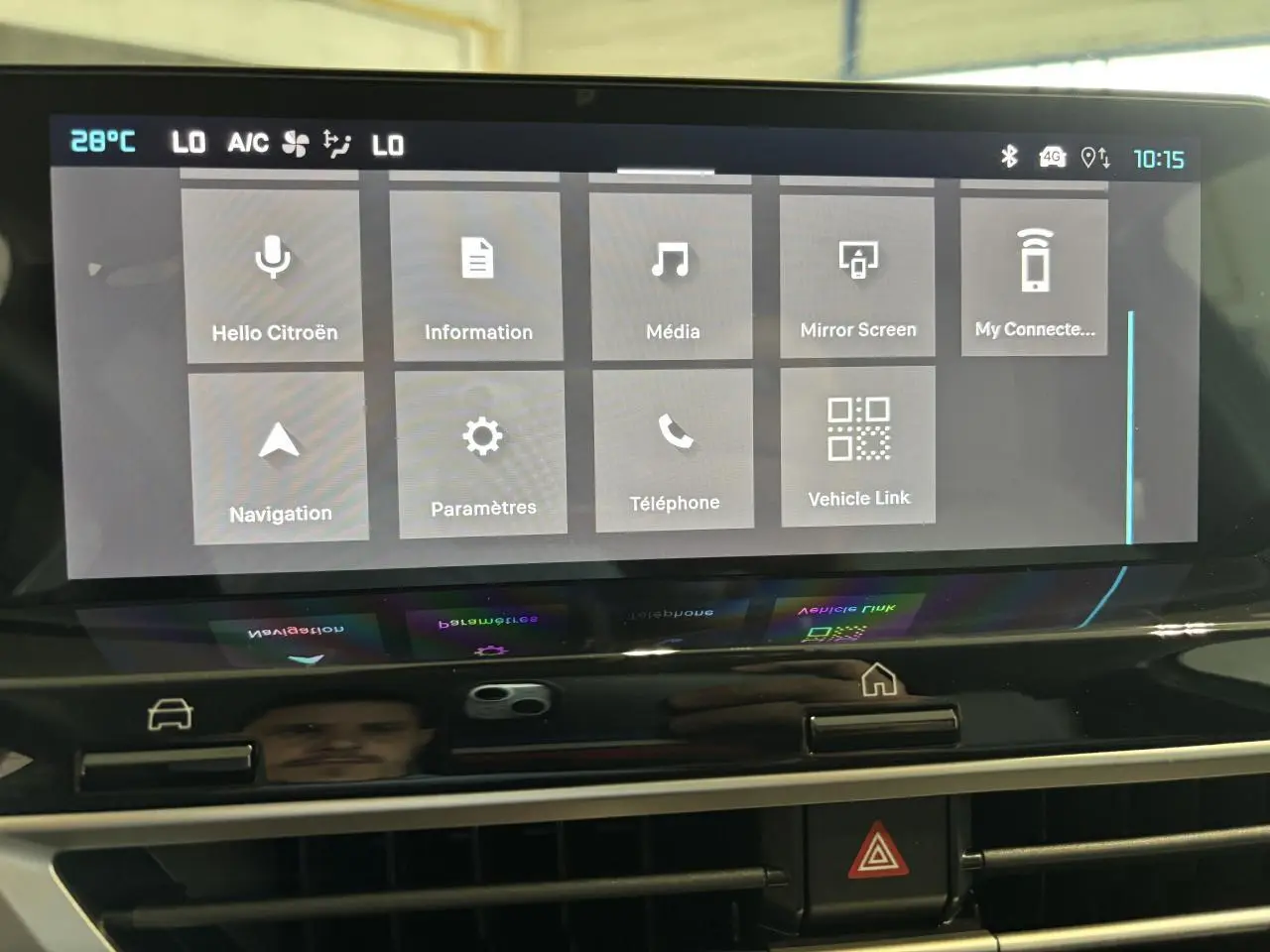 Écran tactile central de la Citroën C4 hybride 2026 affichant le menu principal avec commandes climatisation et navigation.