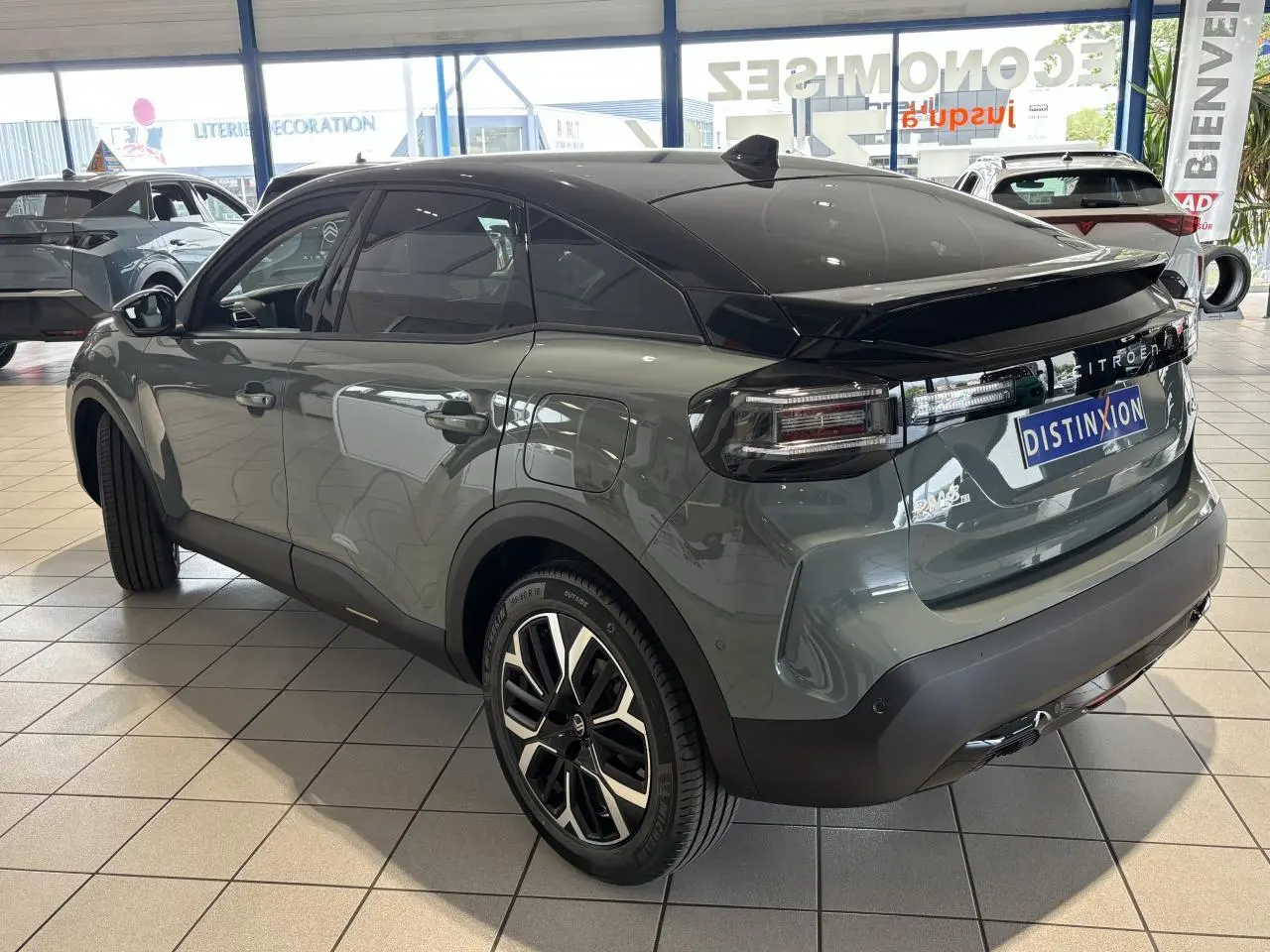 Citroën C4 hybride vert Manhattan, vue 3/4 arrière droit, toit noir Perla Nera et jantes alliage 18 pouces.