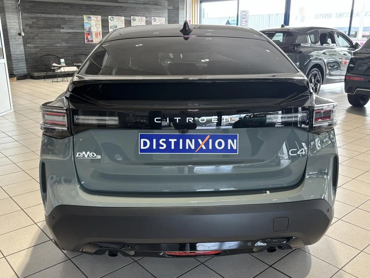 Vue arrière d'une Citroën C4 hybride 2026 vert Manhattan avec toit noir et feux arrière LED distinctifs.