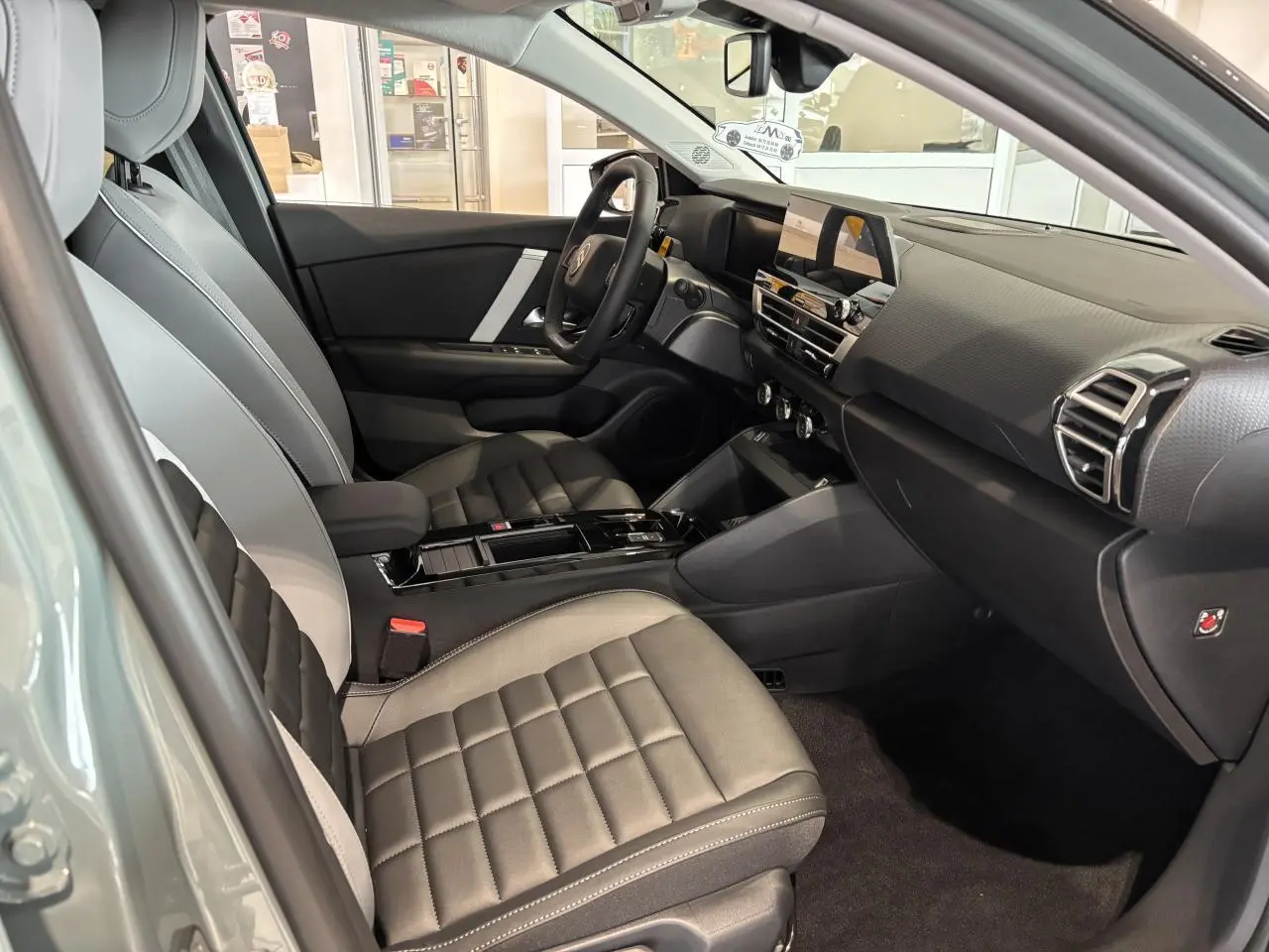 Vue intérieure côté conducteur de la Citroën C4 2026 avec sièges Advanced Comfort gris et tableau de bord moderne.