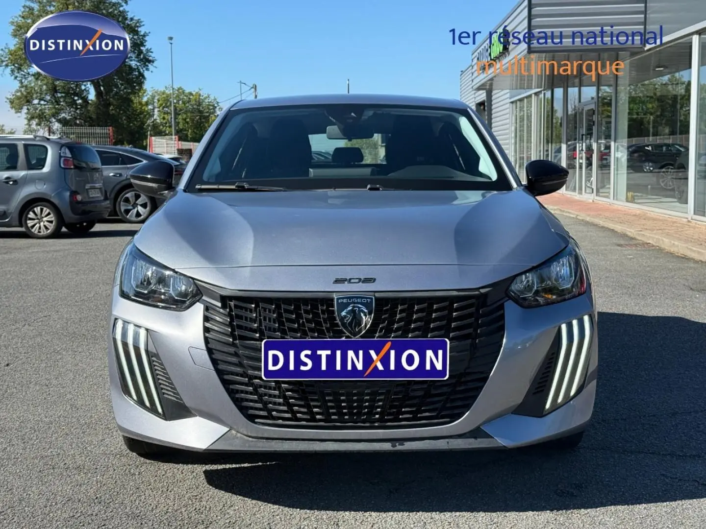 Vue avant d'une Peugeot 208 gris Artense avec calandre noire et feux LED verticaux distinctifs.