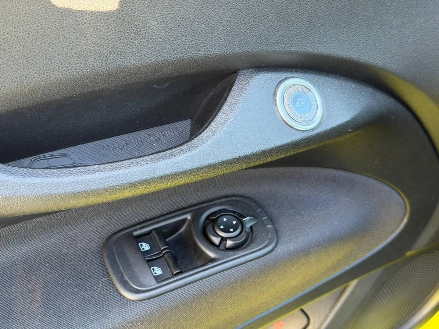 Détail de la porte côté conducteur de la Fiat 500 électrique 2024, montrant les commandes des vitres et rétroviseurs.