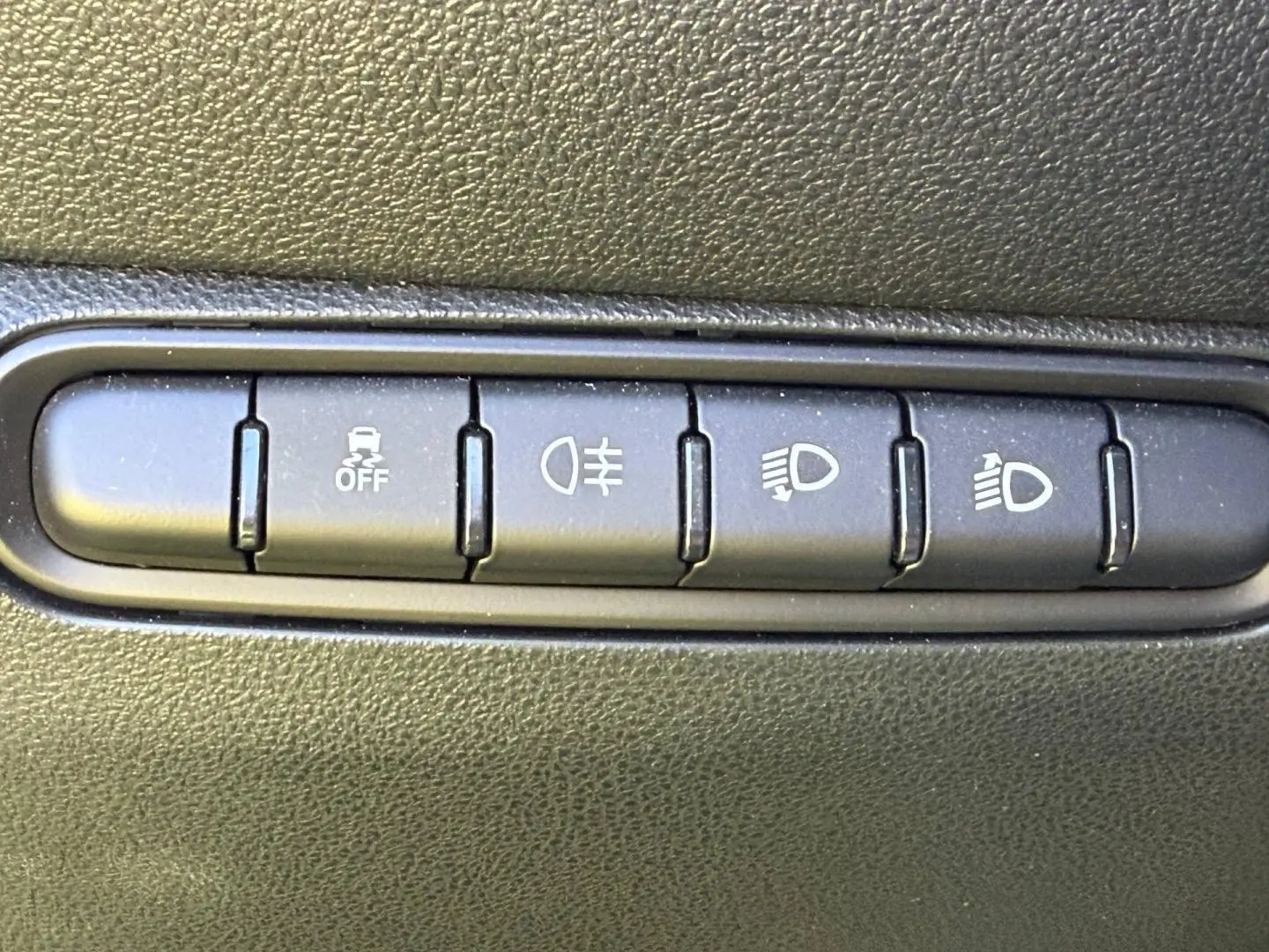 Gros plan sur les boutons de commande d’éclairage et d’assistance au conducteur dans une Fiat 500 e 95ch Pack Confort Ocean Green.