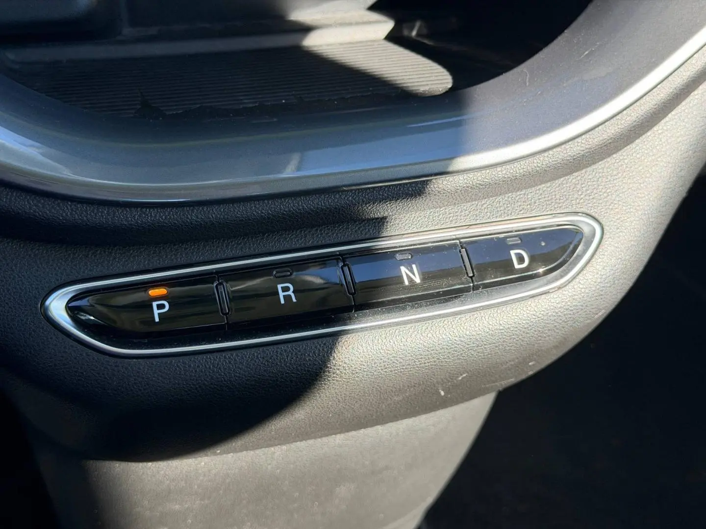 Gros plan sur la commande de boîte automatique noire avec boutons P, R, N, D dans une Fiat 500 électrique 2024 Ocean Green.