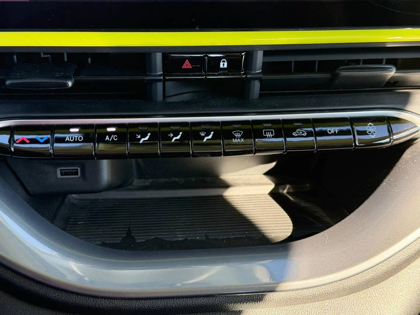 Gros plan sur la rangée de boutons de commande de climatisation dans une Fiat 500 e 95ch Pack Confort Ocean Green métal 2024.