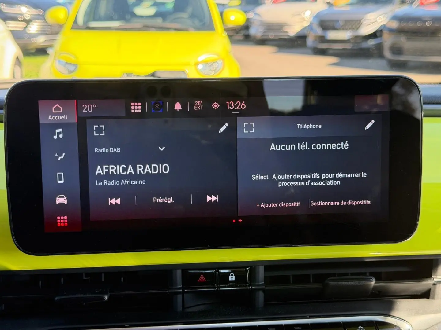 Vue intérieure du tableau de bord de la Fiat 500 e Ocean Green, avec écran tactile multimédia allumé.