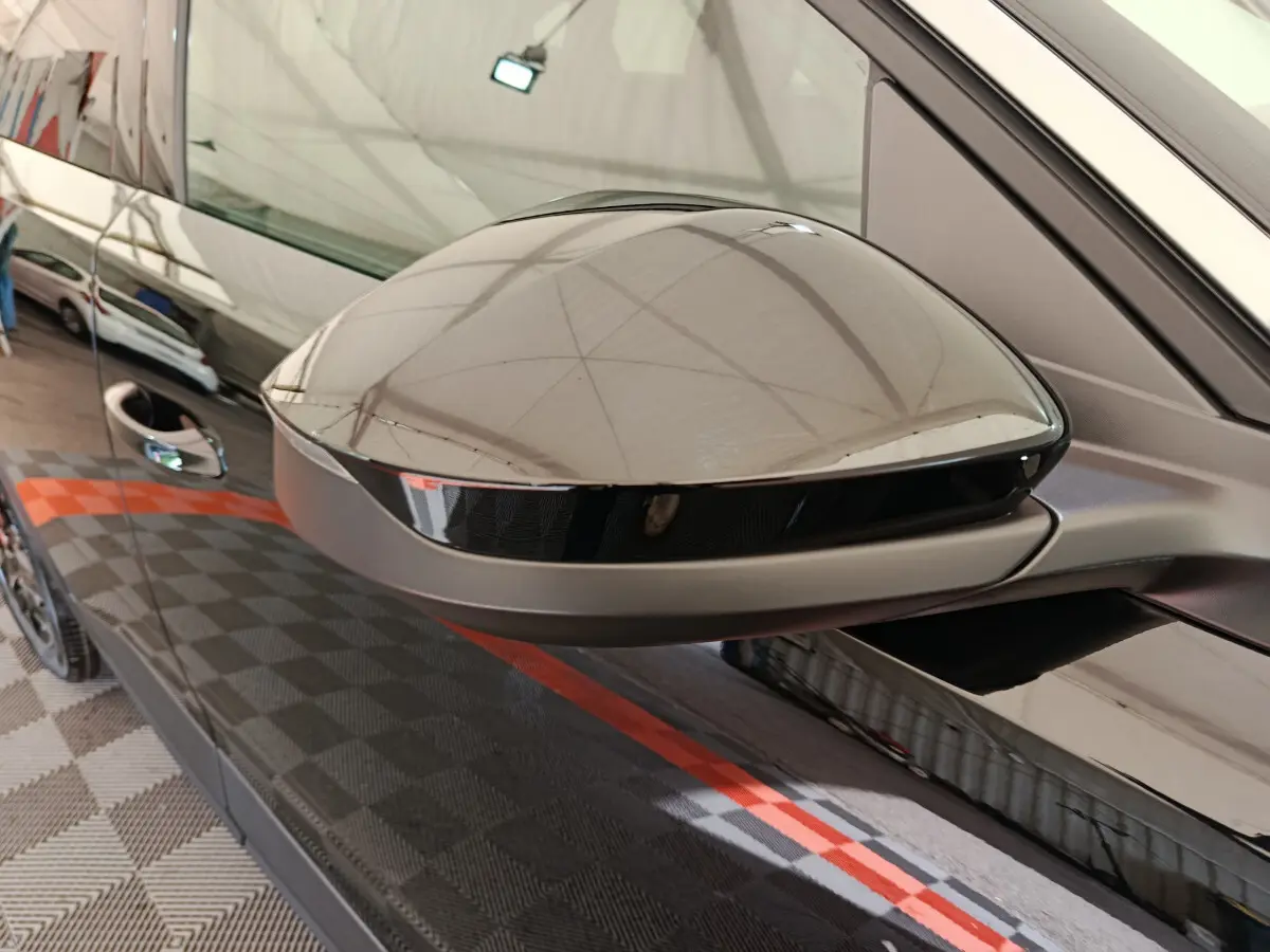 Gros plan sur le rétroviseur côté gauche noir brillant du Peugeot 3008 1.2 HYBRID 145 E-DCS6 GT 2025.