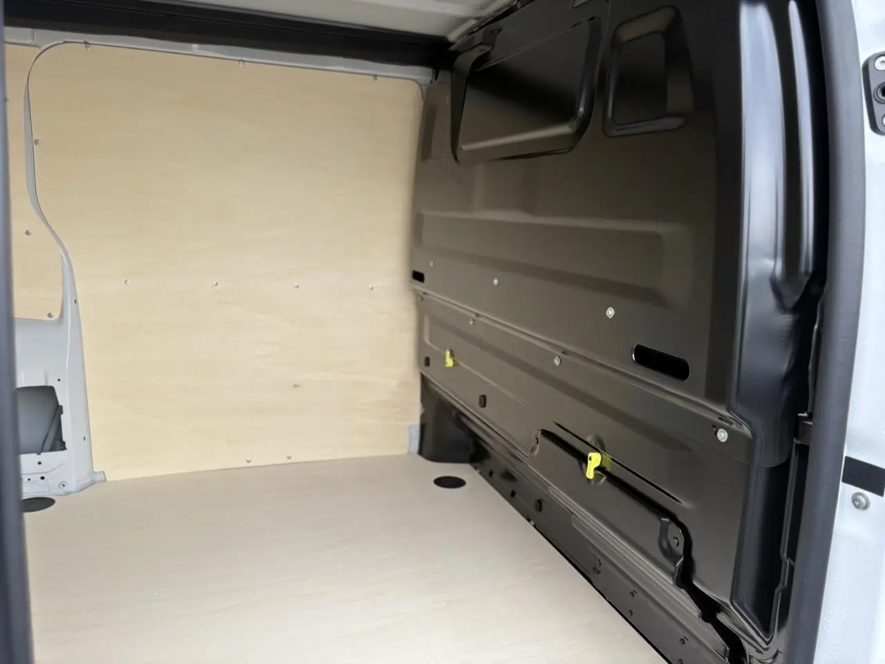 Vue intérieure de la zone de chargement du Peugeot Expert Fourgon blanc Icy, avec parois et plancher en bois clair.