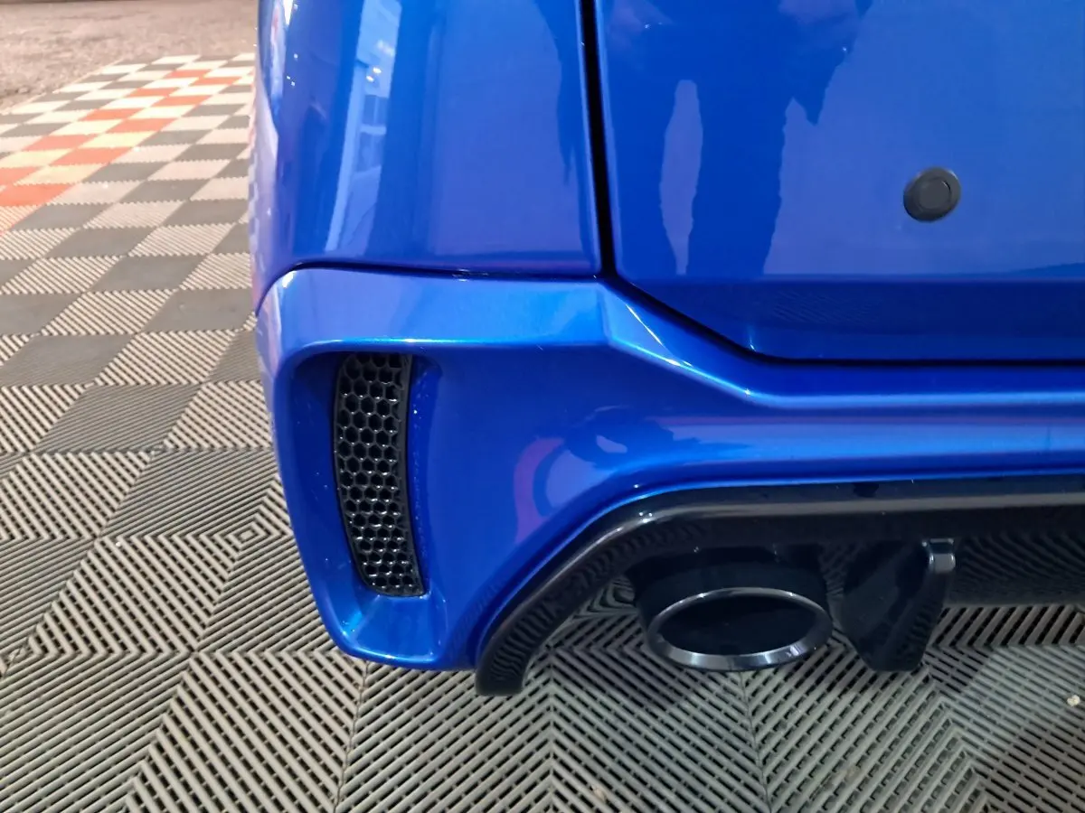 Gros plan sur le coin arrière droit bleu d'une Aixam Ambition 2025 avec sortie d'échappement et prise d'air noire.