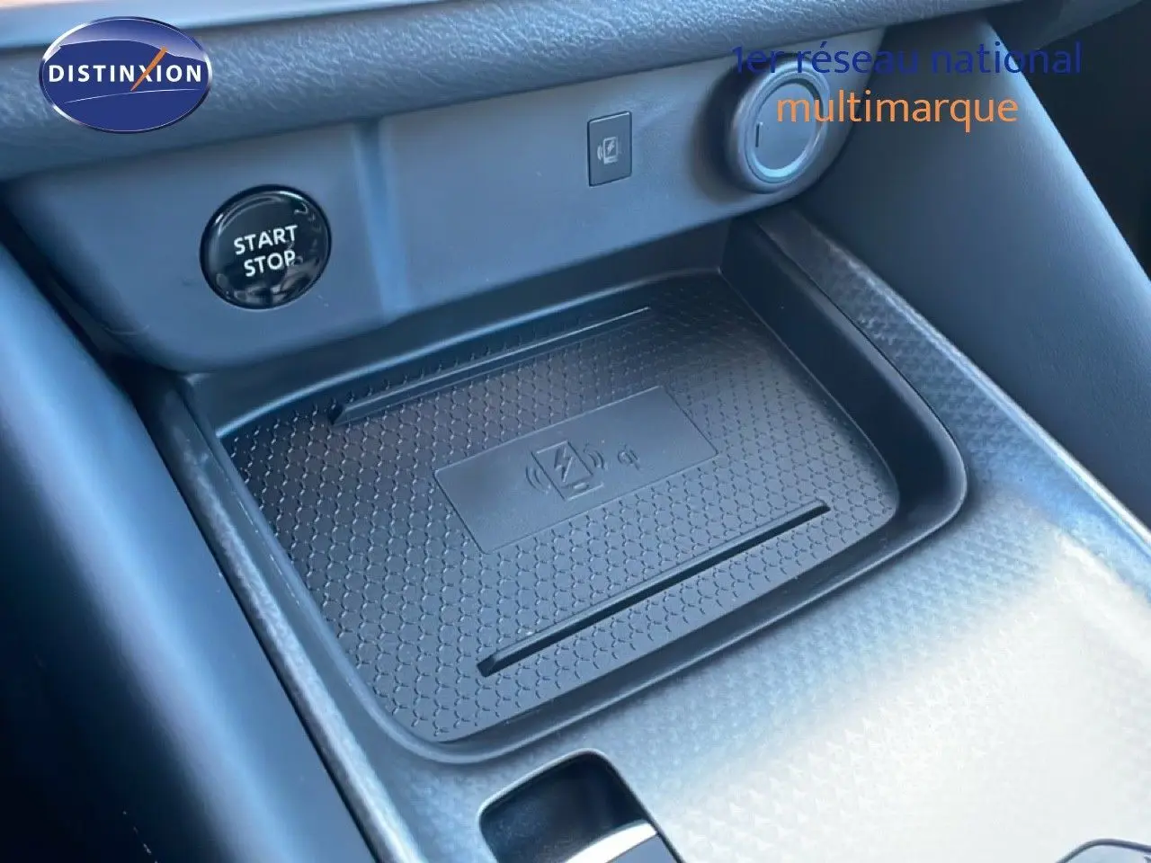 Détail du chargeur sans fil et bouton start/stop dans l’habitacle noir du Nissan Qashqai 2025 gris argile métal.