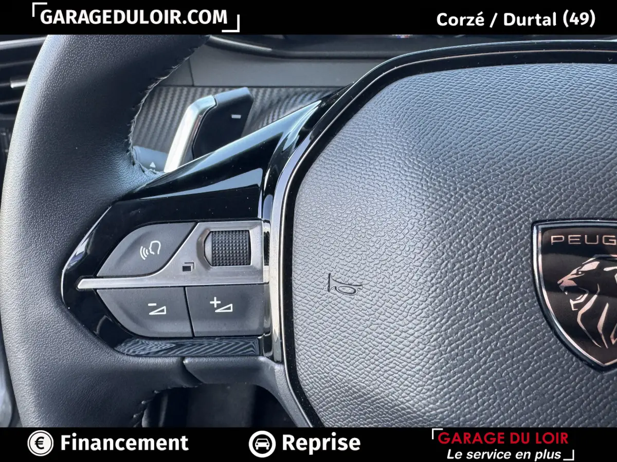Gros plan sur le volant cuir multifonctions de la Peugeot 208 Hybrid 110 e-DCS6 Allure, détail des commandes à gauche.