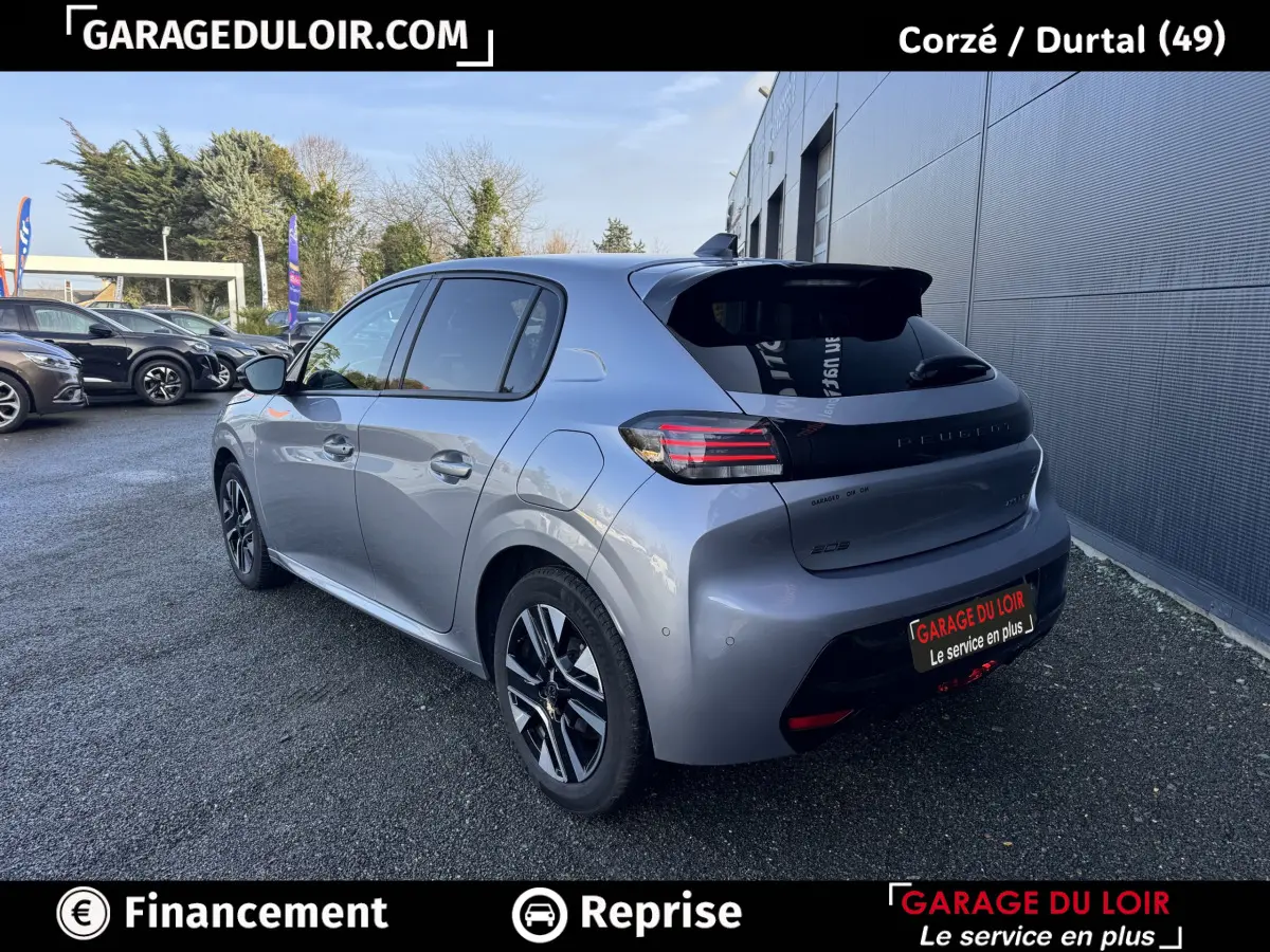 Vue 3/4 arrière droite d'une Peugeot 208 Hybrid 110 gris clair, avec feux arrière LED et jantes alliage noires.