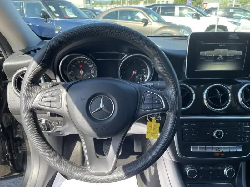 Vue intérieure centrée sur le volant et le tableau de bord d'une Mercedes Classe CLA Shooting Brake noire de 2017.