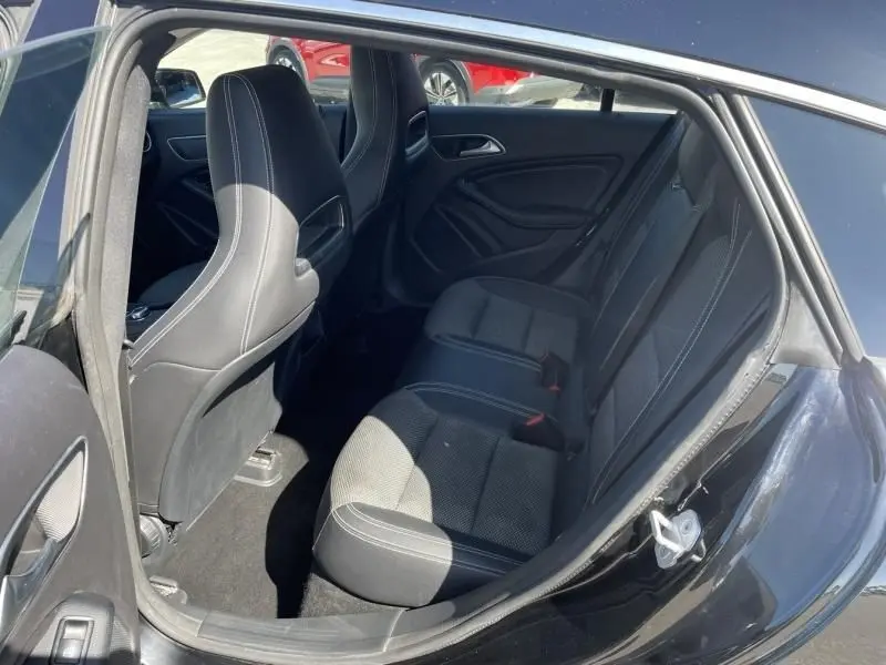 Vue intérieure côté arrière droit du Mercedes Classe CLA Shooting Brake noir, montrant les sièges arrière en tissu et cuir.