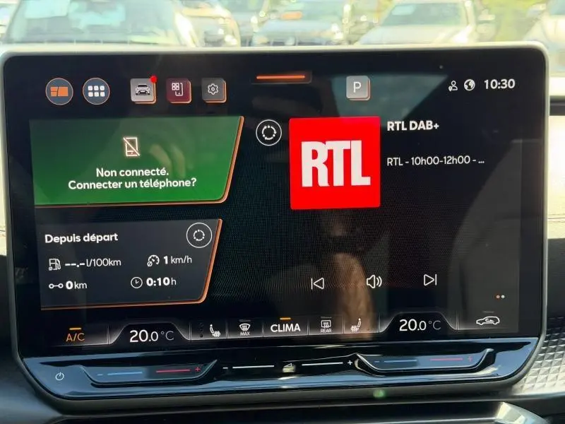 Écran tactile central du tableau de bord du CUPRA Formentor blanc, affichant la radio RTL et la climatisation à 20°C.