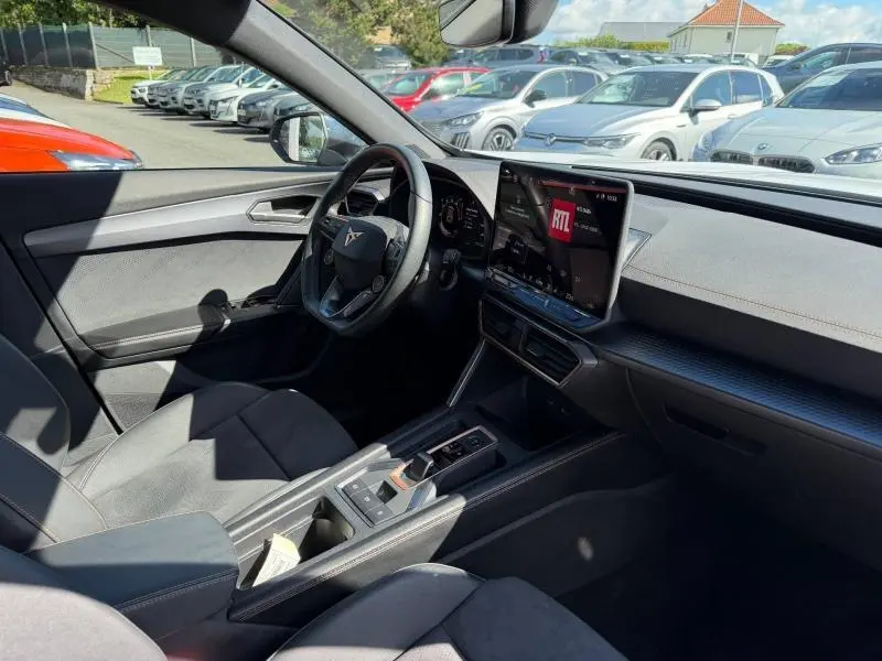 Intérieur de la CUPRA Formentor 1.5 eTSI Hybrid 2025 vu côté conducteur, avec volant cuir multifonction et écran tactile central.