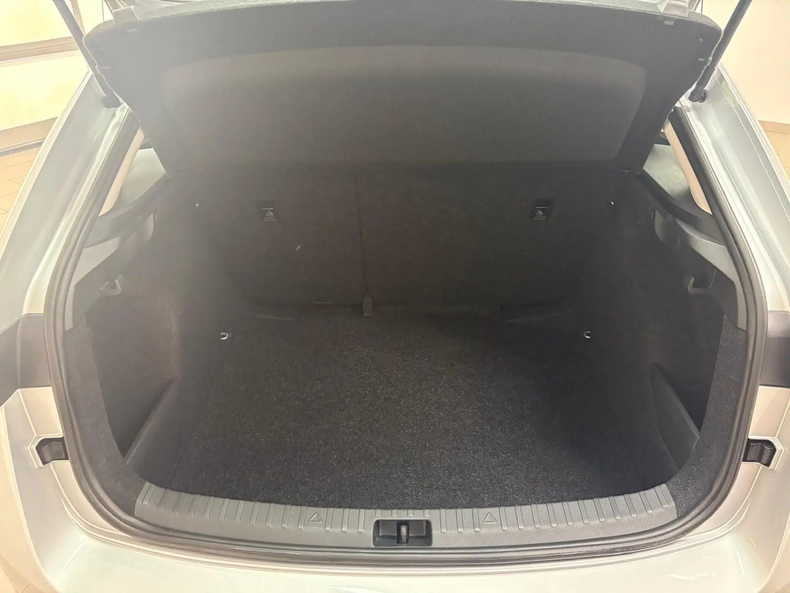 Coffre ouvert vu de l'arrière d'une Skoda Scala gris argent 2024, version 1.0 TSI 110 DSG7 Business, intérieur noir.