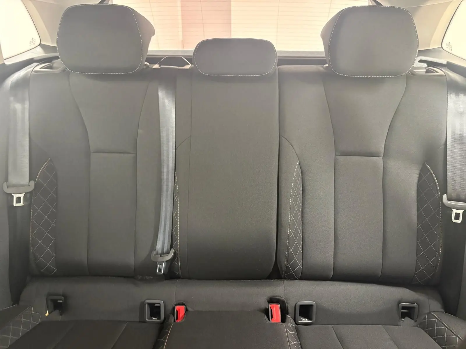 Vue intérieure des sièges arrière noirs avec surpiqûres blanches d'une Skoda Scala 2024, version Business.