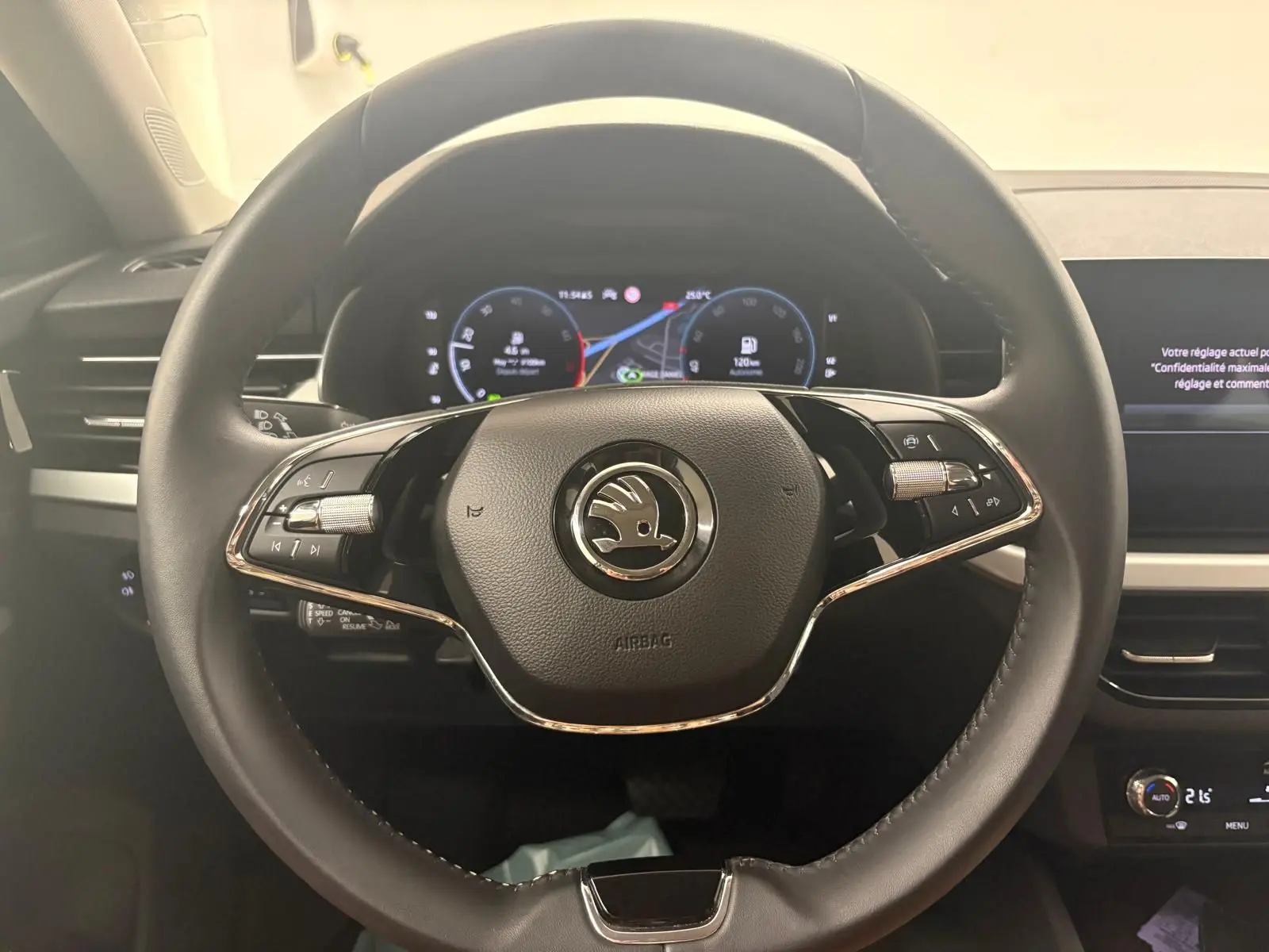 Vue intérieure centrée sur le volant noir du Skoda Scala 2024 avec tableau de bord numérique et commandes intégrées.