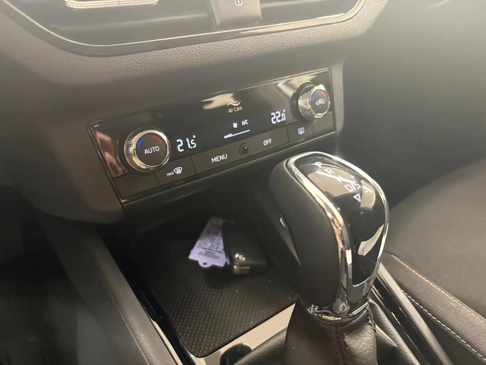 Gros plan sur la console centrale du Skoda Scala gris argent 2024, avec levier de boîte auto et commandes climatisation digitales.