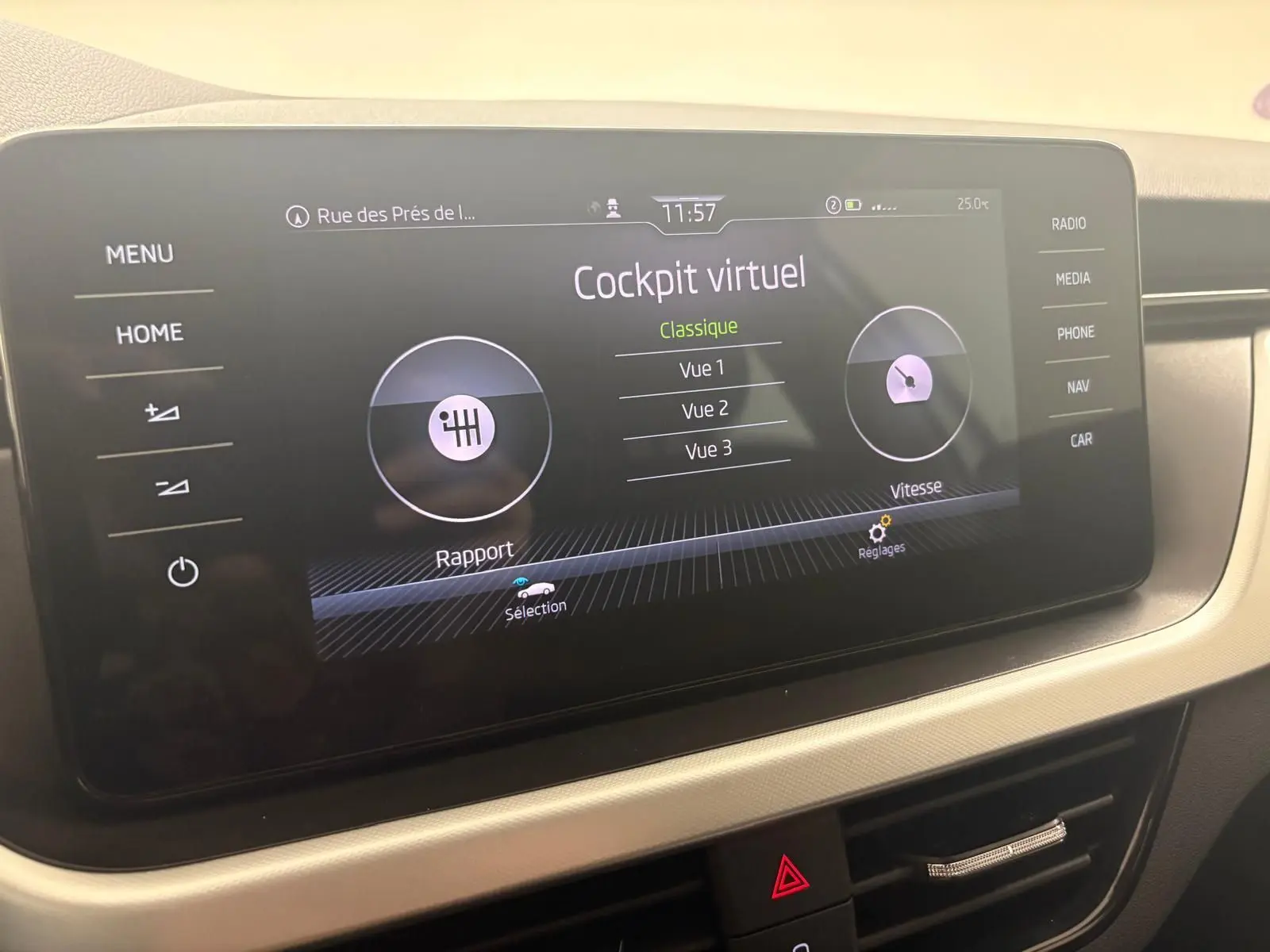 Écran tactile du cockpit virtuel de la Skoda Scala 2024, affichant les options de vue et réglages, intérieur beige.