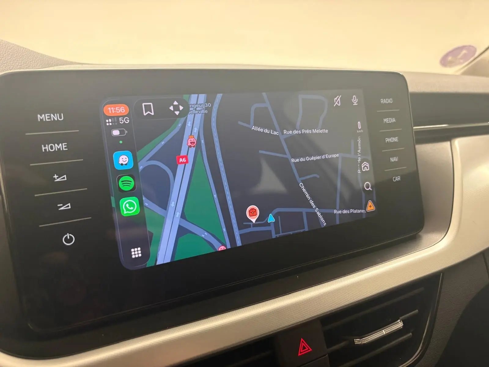 Écran tactile central du Skoda Scala 2024 affichant la navigation GPS avec commandes tactiles autour, intérieur beige.