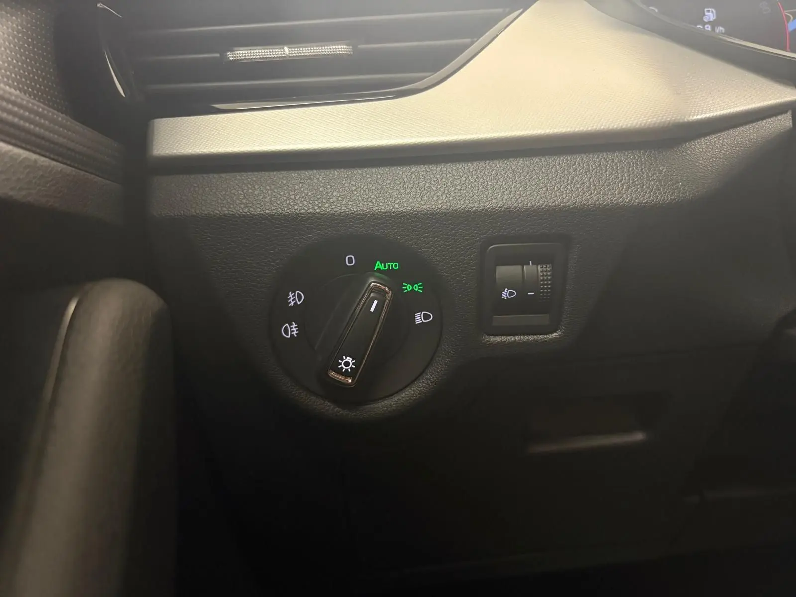 Détail du tableau de bord côté gauche du Skoda Scala 2024, montrant la commande des phares avec réglage automatique allumé.