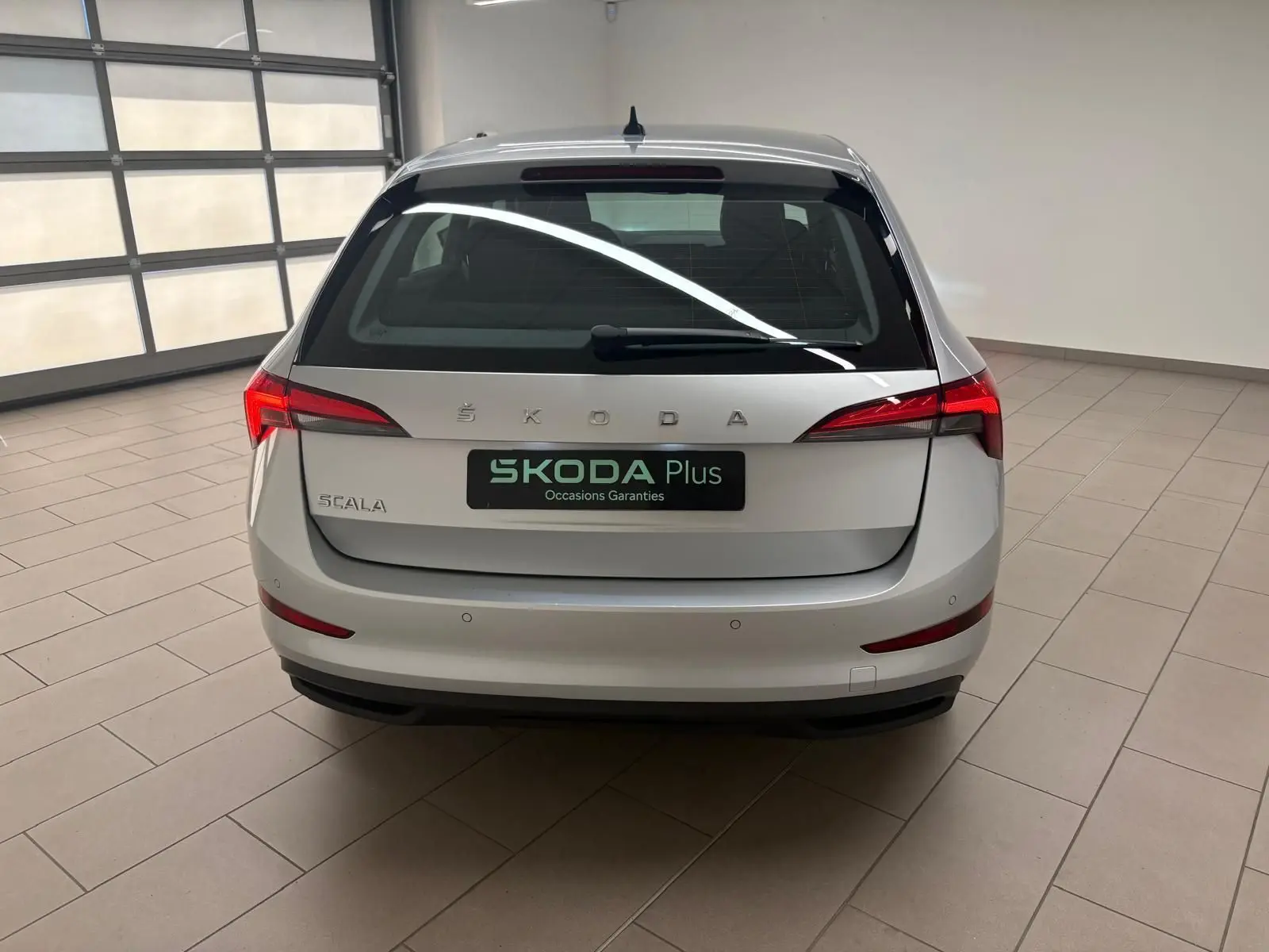 Vue arrière d'une Skoda Scala gris argent 2024, avec feux arrière LED et logo ŠKODA bien visible.