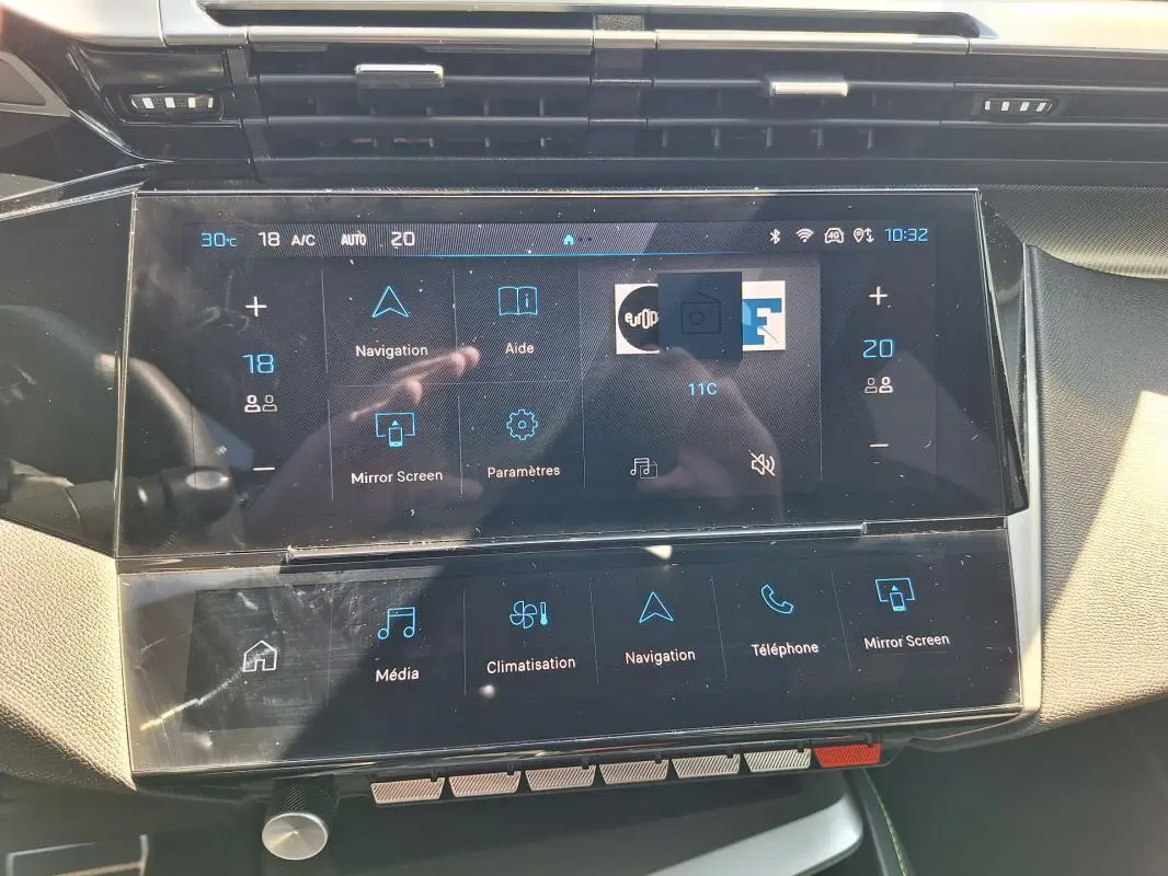 Écran tactile central du tableau de bord du Peugeot 308 SW Hybrid 145 e-DCS6 GT, affichant les commandes de navigation et climatisation.