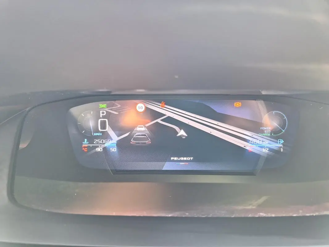 Affichage numérique du cockpit de la Peugeot 308 SW Hybrid 145 GT montrant la vitesse, navigation et indicateurs divers.