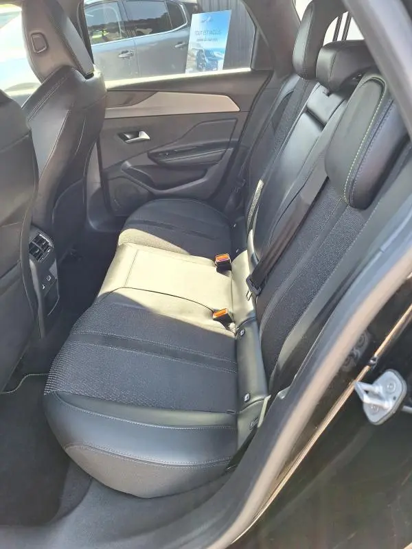 Vue intérieure côté droit des sièges arrière noirs en cuir et tissu du Peugeot 308 SW Hybrid 145 e-DCS6 GT 2025.